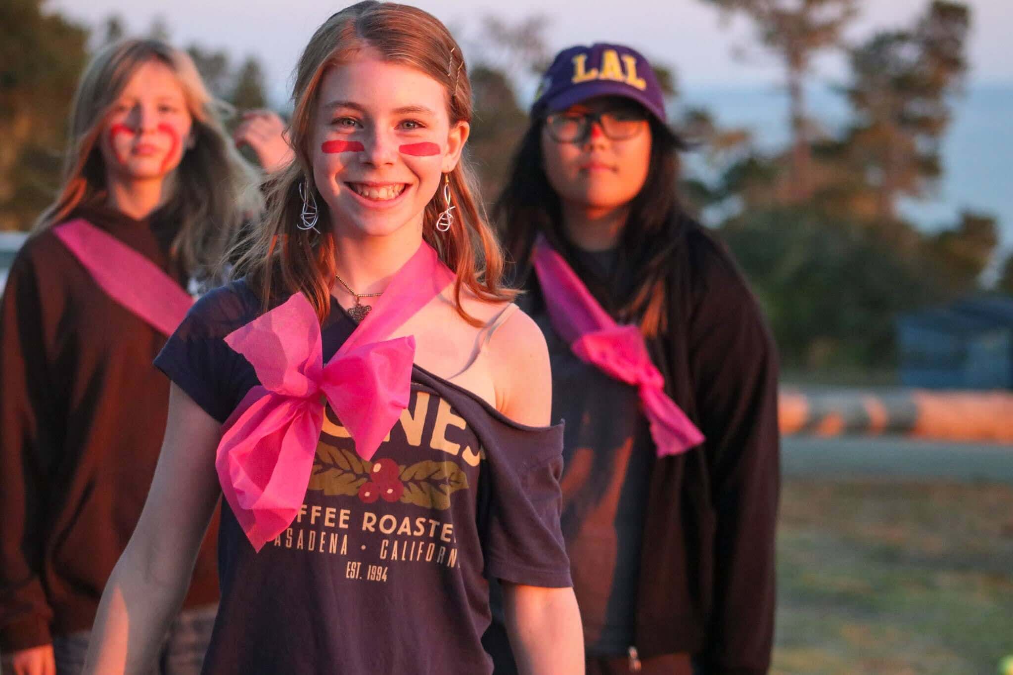 Kids enjoying summer camp at Camp Ocean Pines, wearing colorful sashes and face paint, capturing fun moments outdoors.
