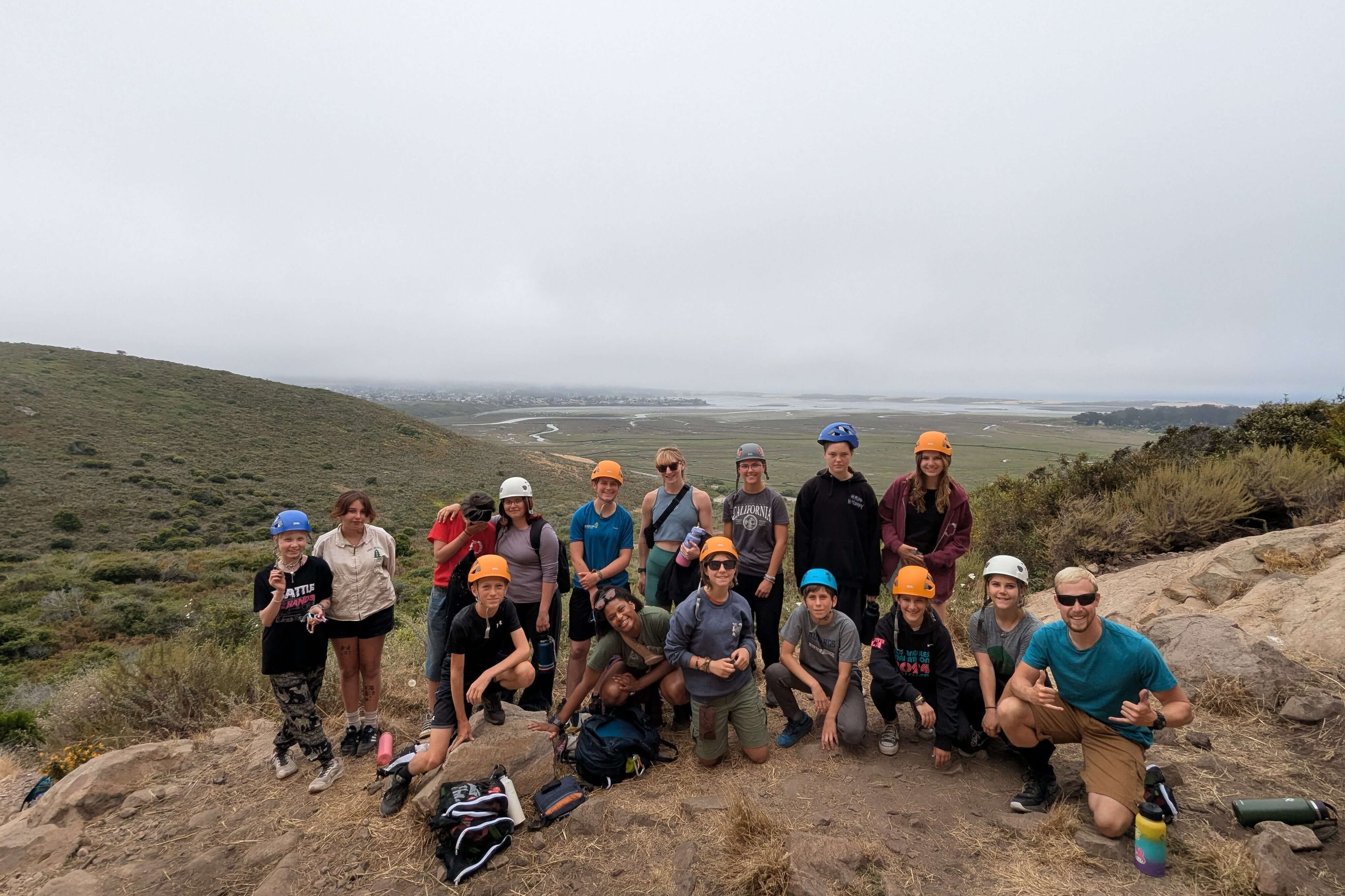 Camp Ocean Pines summer camp group exploring nature in California, sporting helmets and smiles on a hiking adventure.