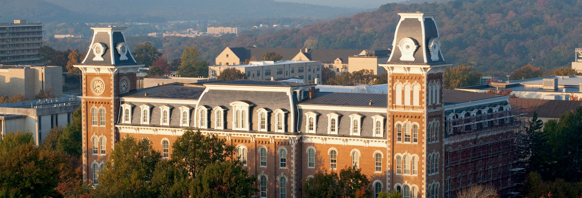 Aerial view of a historic college building surrounded by trees and mountains, showcasing summer camp programs for high school and college students.