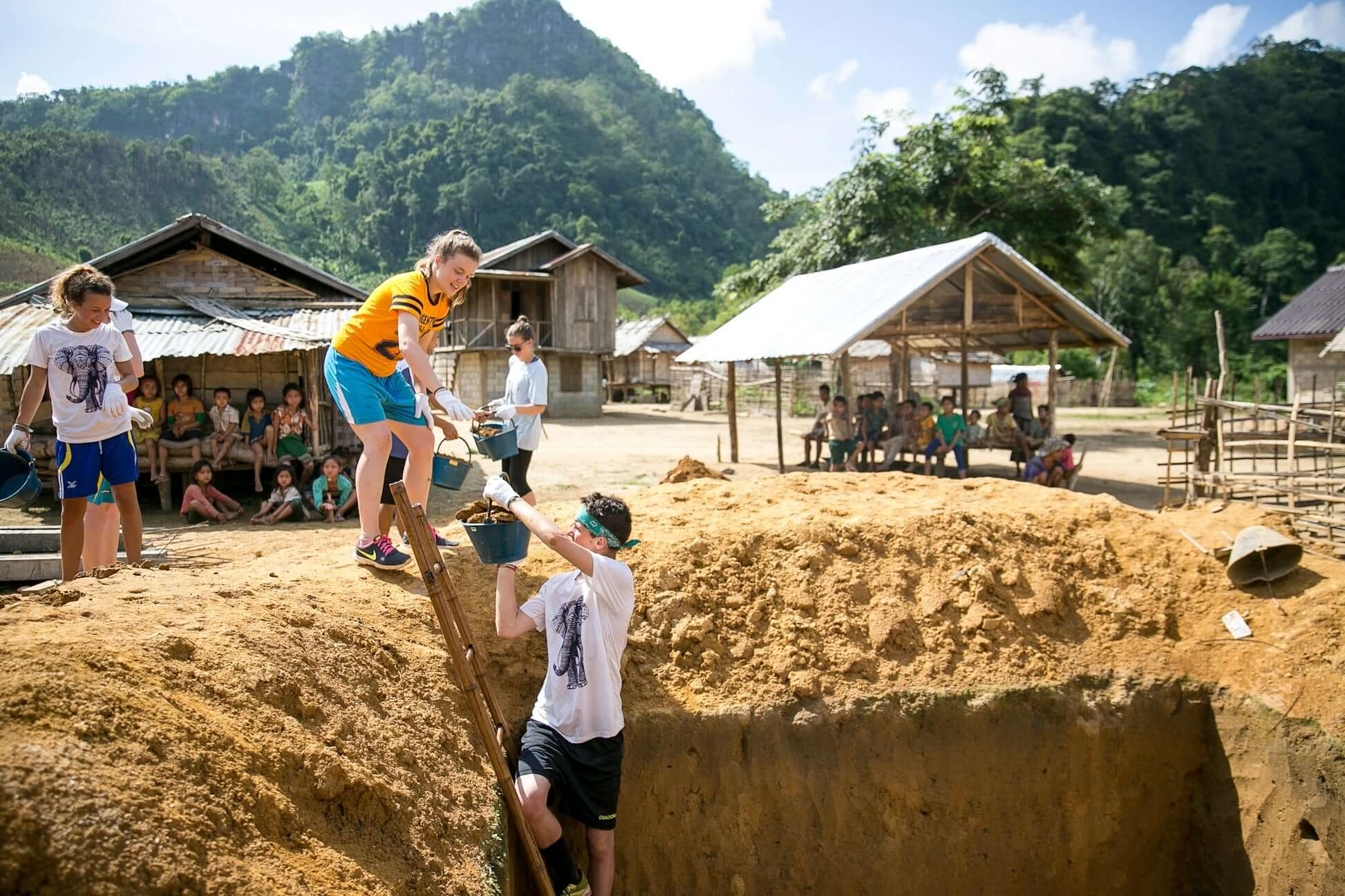 teens participate in a service expedition in rural Thailand, helping with community projects in a village setting.