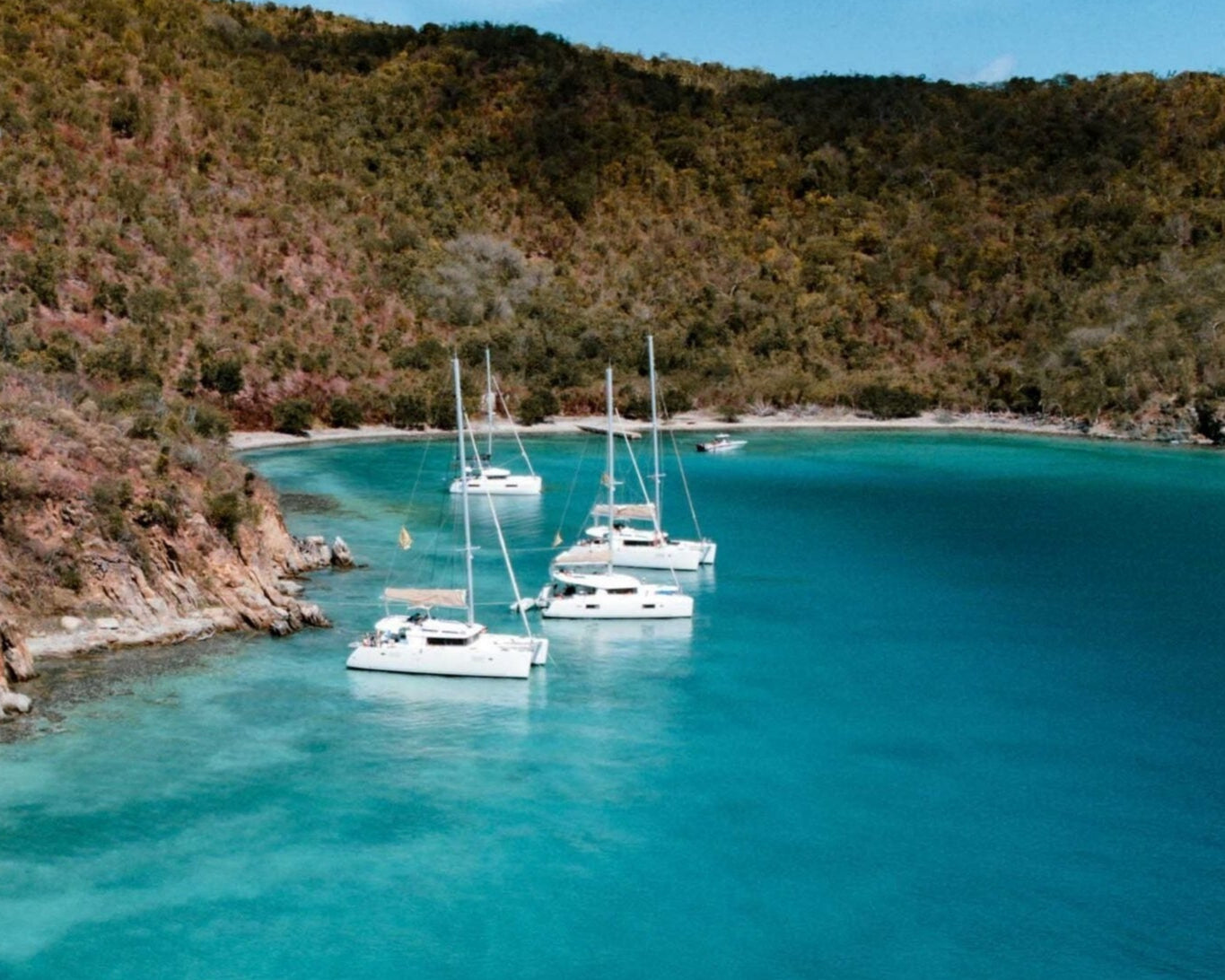 Scenic view of sailing yachts anchored in crystal-clear waters of the British Virgin Islands, ideal for summer programs.