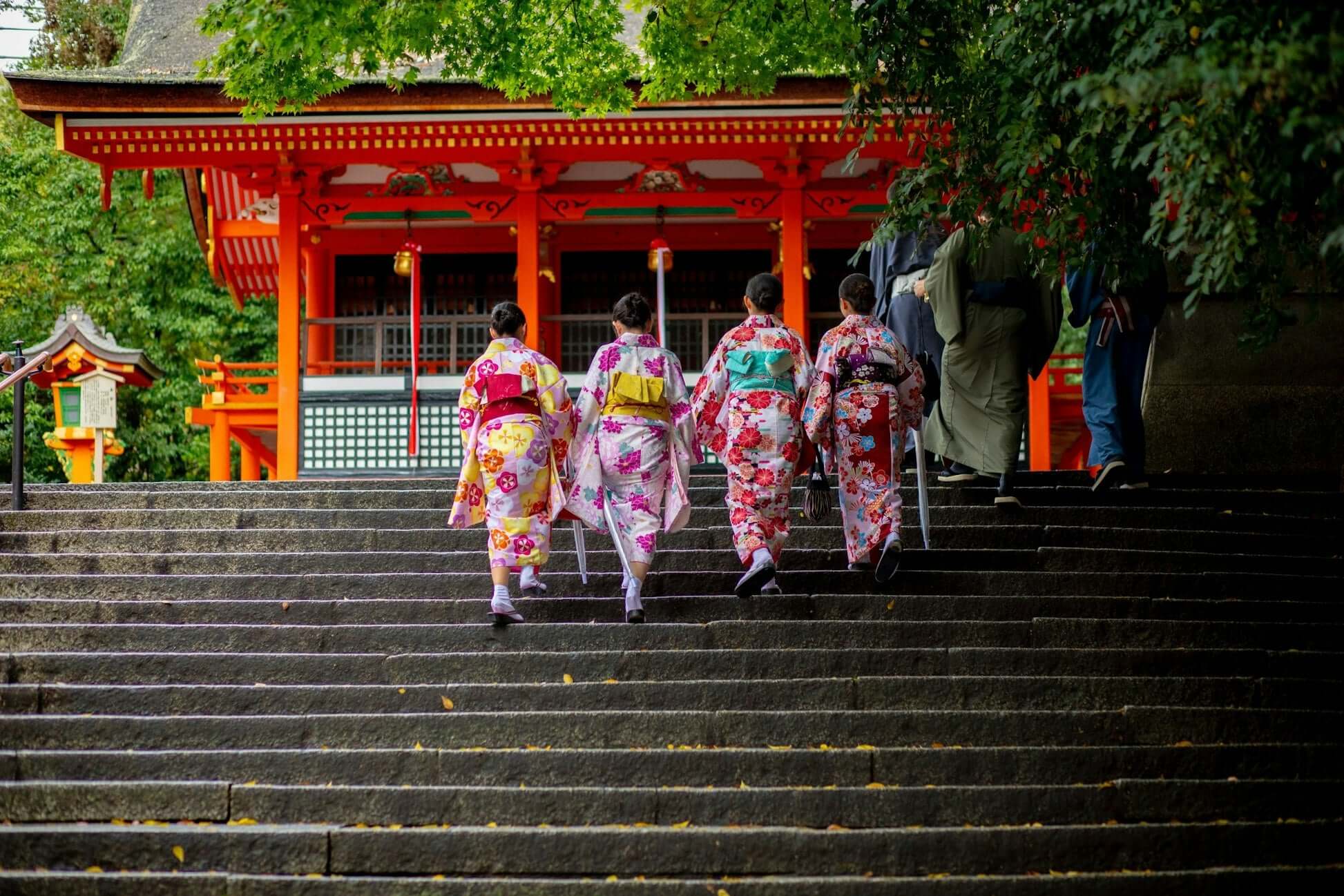 High school students in traditional kimonos visiting a shrine in Japan during a summer program for teen travel.