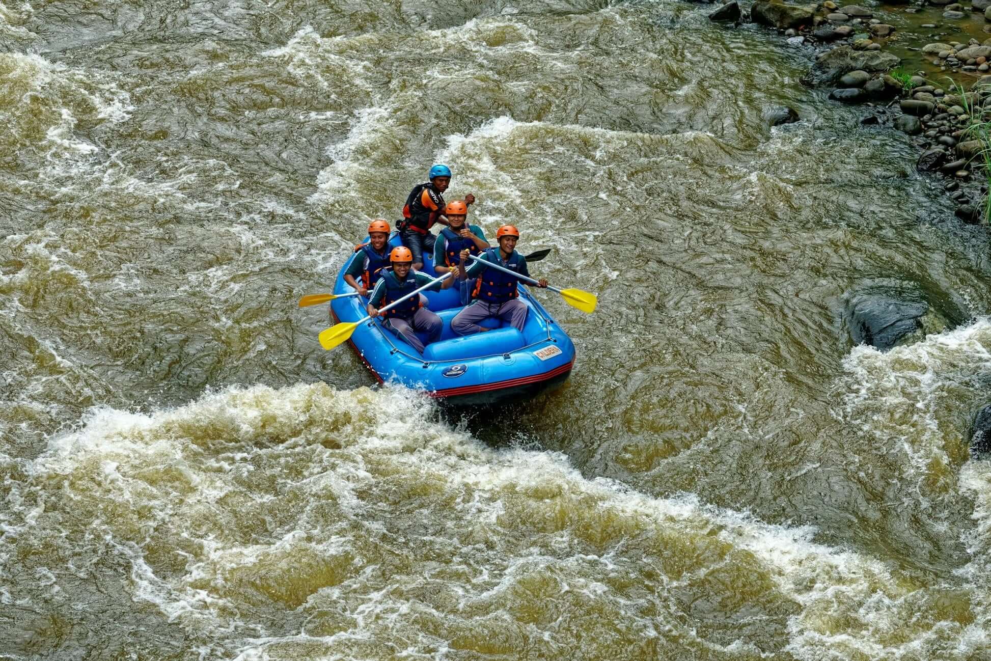 Group of high school students rafting through rapids during a summer adventure program in the Bavarian Alps.