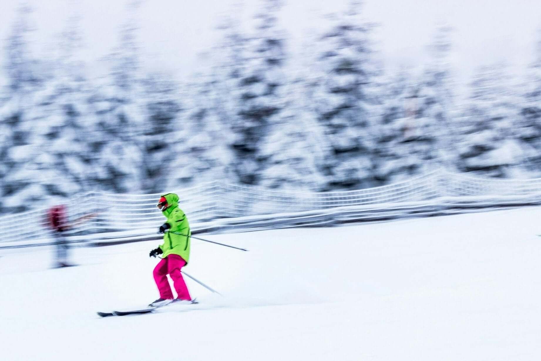 Teen skier in bright winter gear gliding through snowy landscape, showcasing winter sports in Germany and Austria.