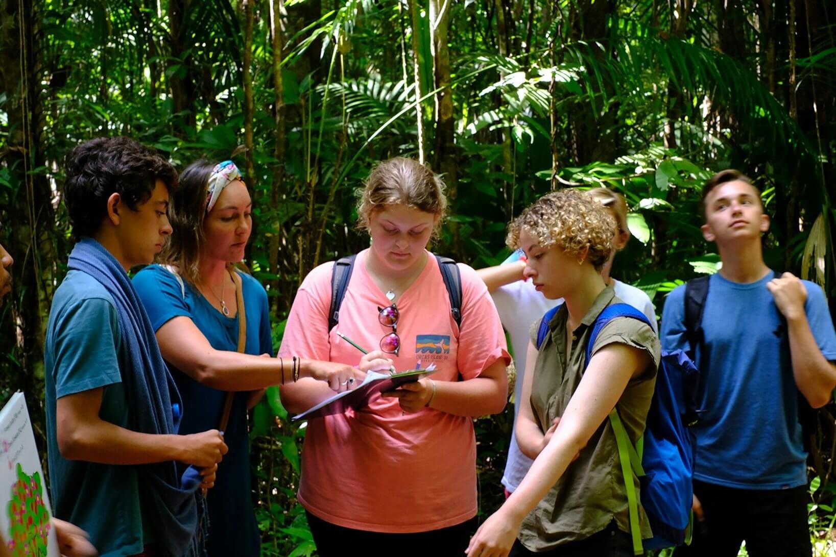 students engaged in rainforest conservation education in southern Thailand's lush landscape during summer travel.