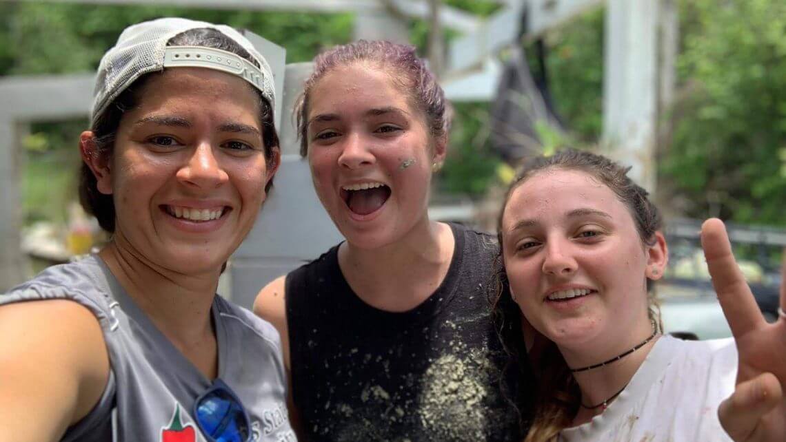 Teens participating in a hurricane relief service trip in Puerto Rico, smiling and engaged in community work.