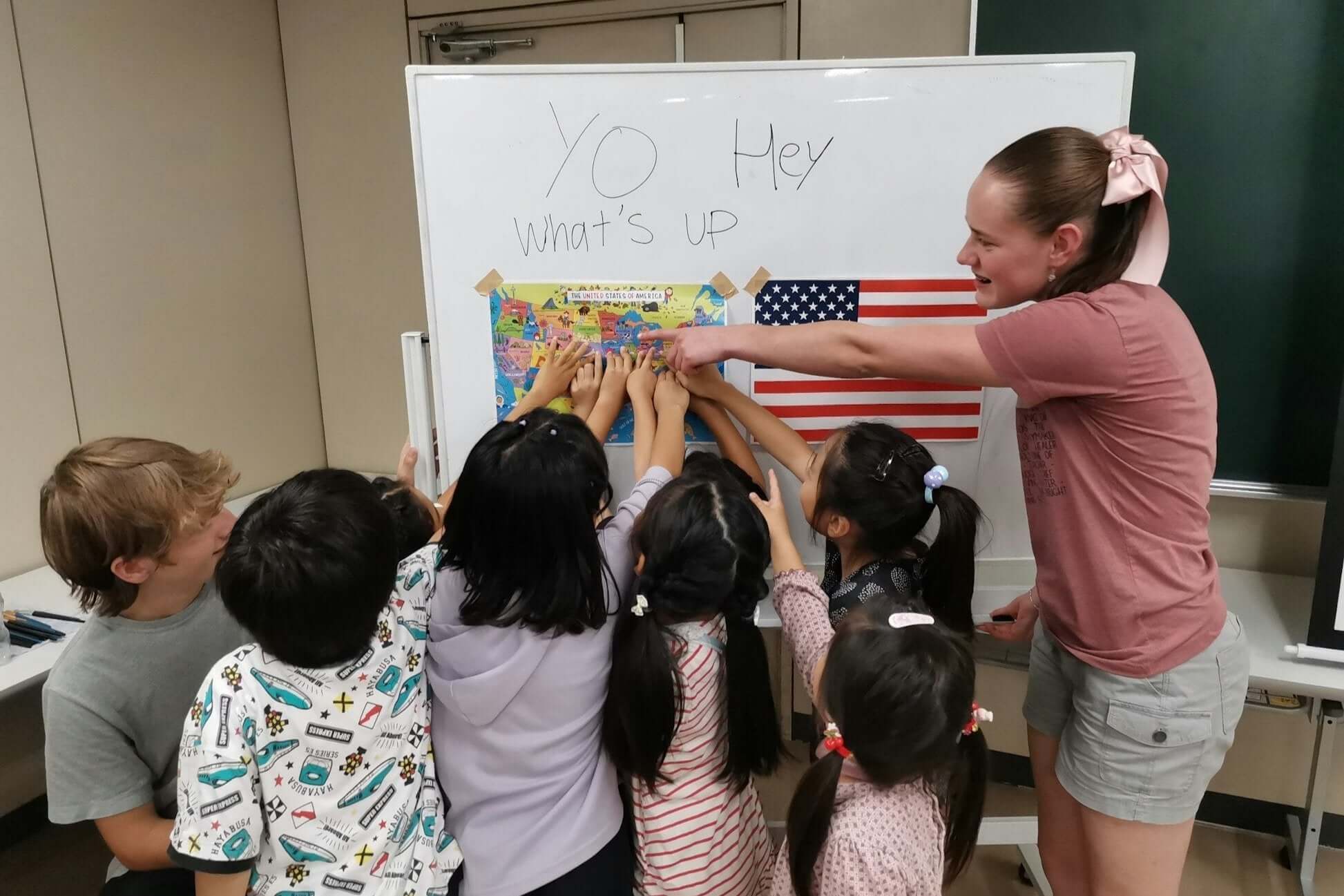 Children engaging in a fun educational activity with a teacher in a classroom, exploring culture and geography.