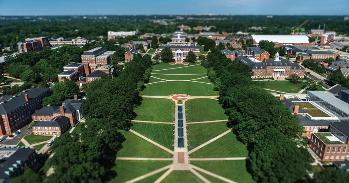 Aerial view of a university campus featuring green lawns, pathways, and academic buildings, ideal for summer camps and programs.