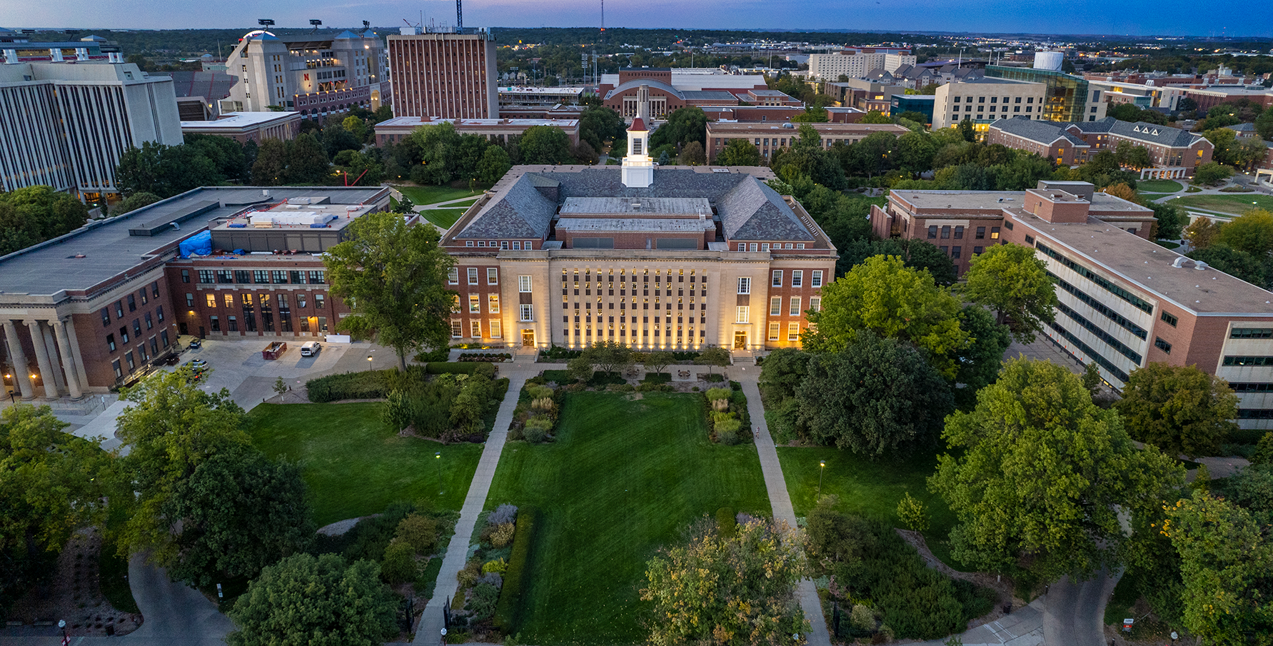 Aerial view of a university campus showcasing lush greenery and prominent buildings, symbolizing summer programs for high school and college.