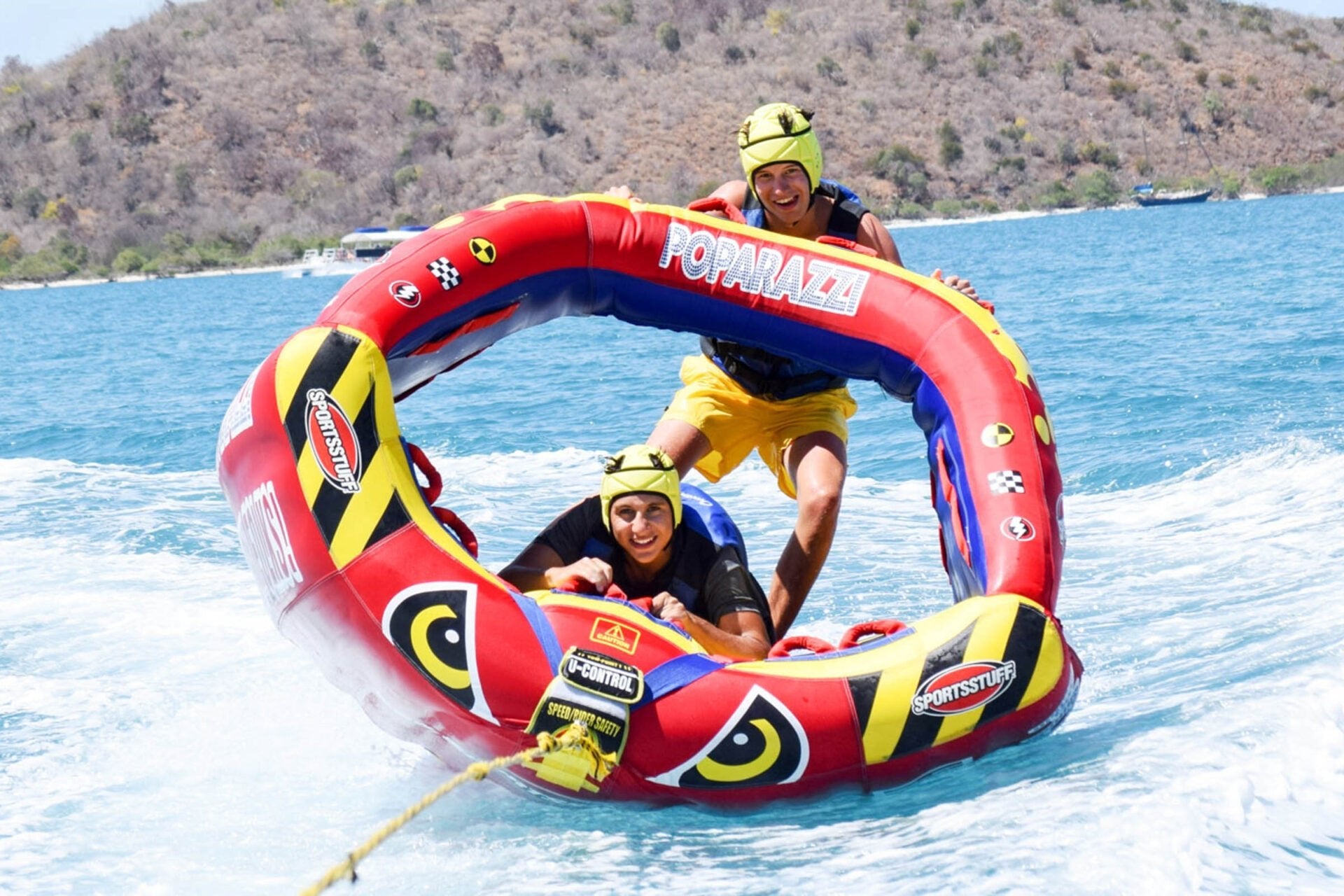 Teens enjoying tubing fun on a vibrant inflatable raft during summer programs in the Caribbean.