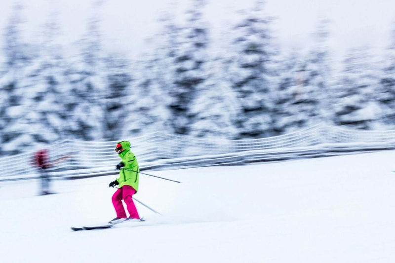 Teen skier in bright winter gear gliding through snowy landscape, showcasing winter sports in Germany and Austria.